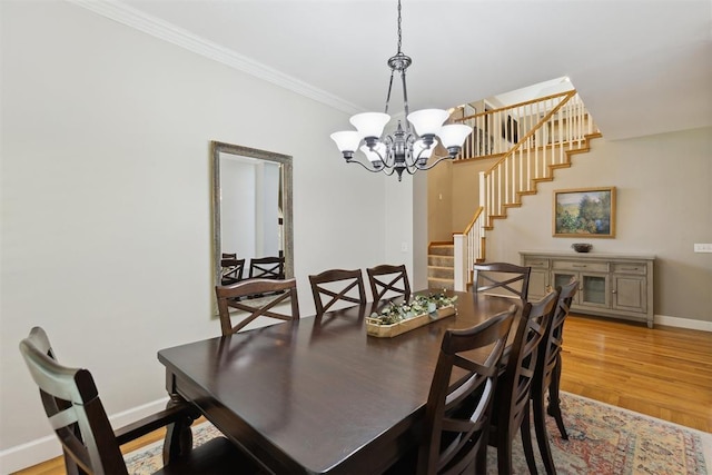 dining area featuring stairs, ornamental molding, a chandelier, baseboards, and light wood-style flooring