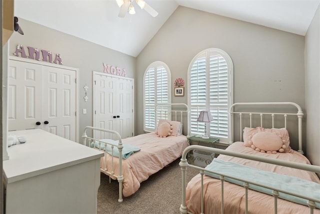 carpeted bedroom with multiple closets, vaulted ceiling, and a ceiling fan
