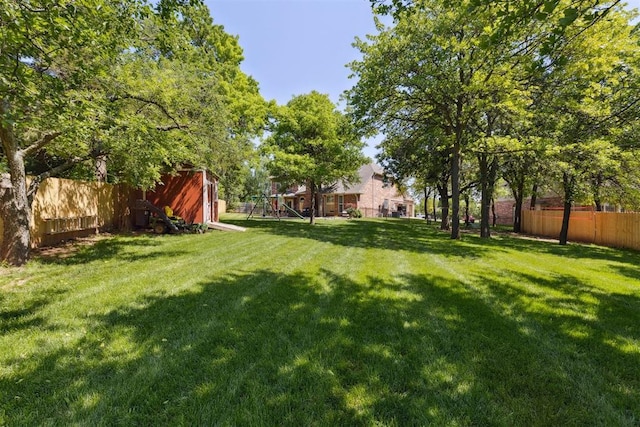 view of yard with a playground and a storage unit