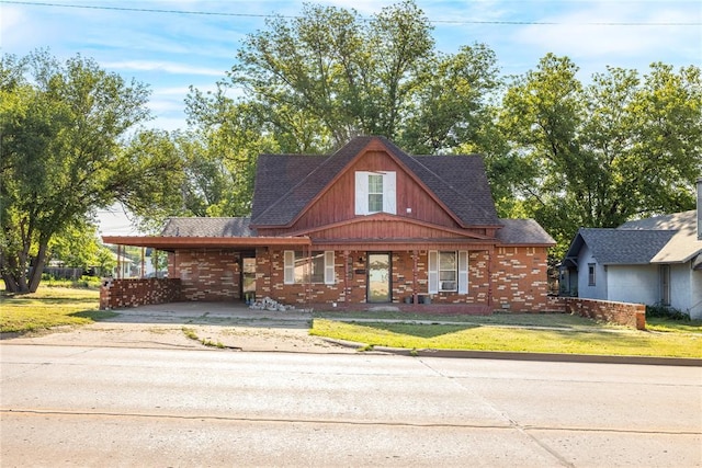 view of front of home featuring driveway, an attached carport, brick siding, and a front lawn