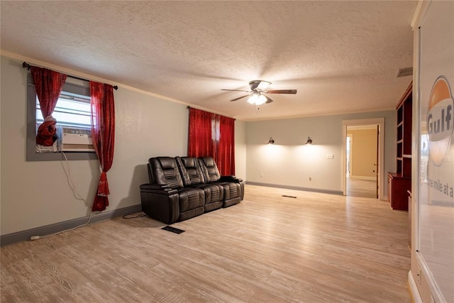 unfurnished living room with a ceiling fan, light wood-type flooring, a textured ceiling, baseboards, and crown molding