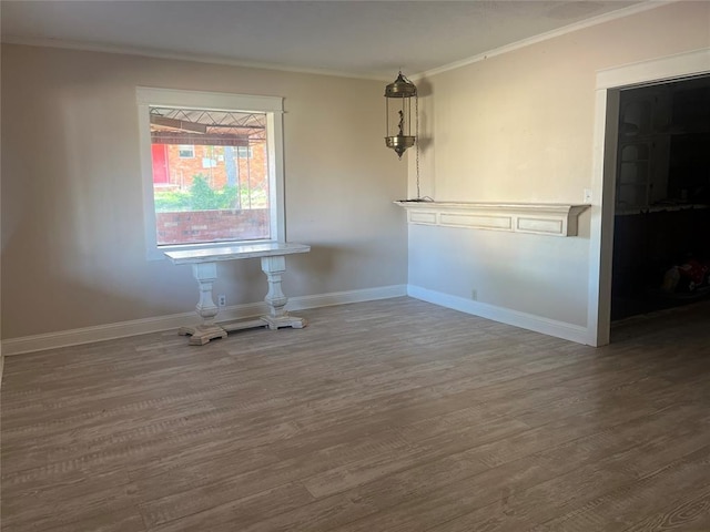 unfurnished dining area featuring ornamental molding, wood finished floors, and baseboards
