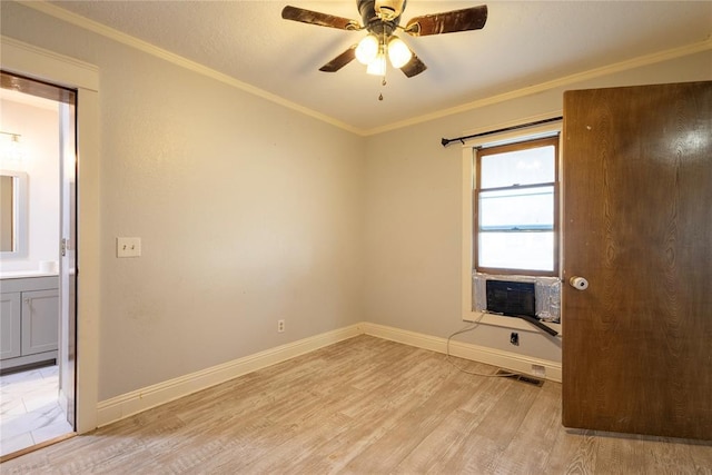 empty room featuring light wood-style floors, a ceiling fan, cooling unit, baseboards, and crown molding