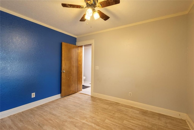 spare room with wood finished floors, baseboards, ceiling fan, and ornamental molding
