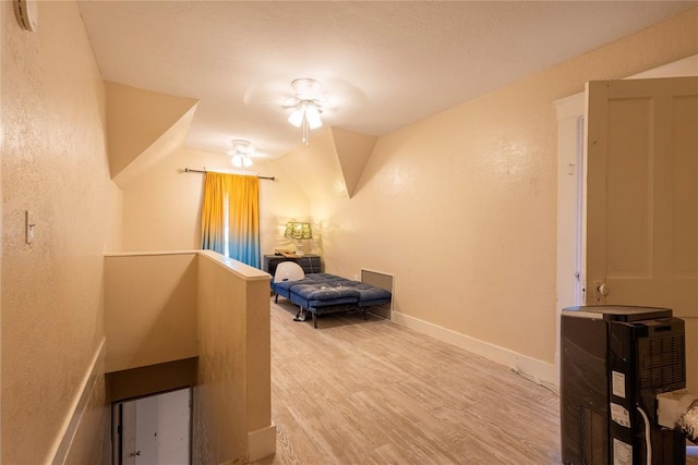 bedroom with wood finished floors and a textured wall