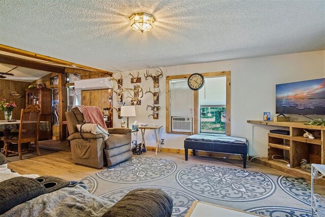 114166 S 4209th Rd, Eufaula, OK 74432 - living room featuring wood finished floors, a textured ceiling, a wall mounted air conditioner, wood walls, and cooling unit