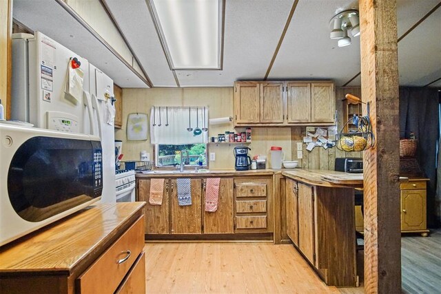114166 S 4209th Rd, Eufaula, OK 74432 - kitchen with light wood-style floors, wooden counters, white refrigerator with ice dispenser, brown cabinetry, and a sink