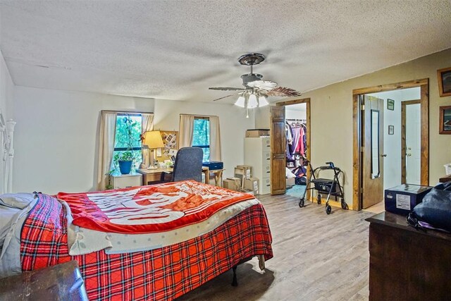 114166 S 4209th Rd, Eufaula, OK 74432 - bedroom featuring wood finished floors, a textured ceiling, a spacious closet, a ceiling fan, and a closet