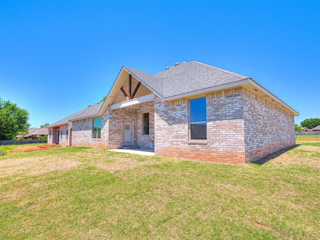 2716 Dunham Dr, Norman, OK 73071 - back of house with brick siding, a lawn, and a shingled roof