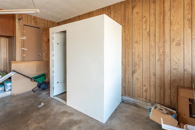 2613 SW 95th St, Oklahoma City, OK 73159 - empty room featuring wooden walls, unfinished concrete flooring, and a textured ceiling
