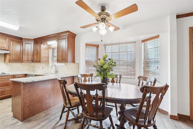 dining space with light wood-style floors, ceiling fan, and baseboards