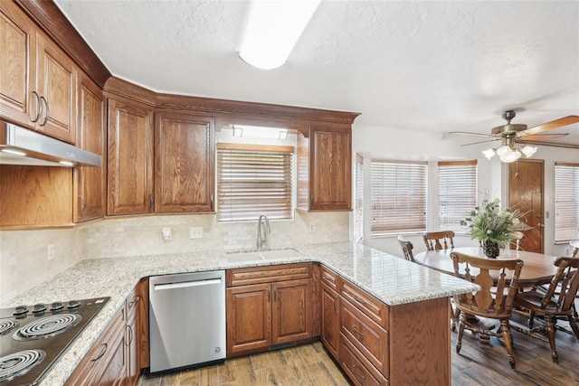kitchen with stainless steel dishwasher, a sink, black electric stovetop, ceiling fan, and light wood-style floors