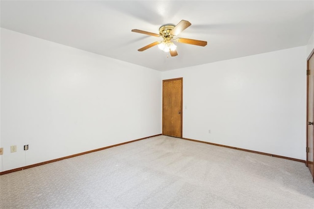 unfurnished room with a ceiling fan, light colored carpet, and baseboards