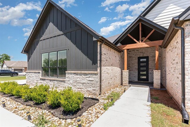 2246 Jackson Ln, Blanchard, OK 73010 - view of exterior entry with board and batten siding and stone siding