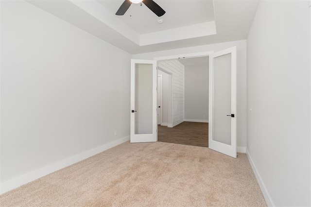 2246 Jackson Ln, Blanchard, OK 73010 - carpeted empty room featuring french doors, a raised ceiling, a ceiling fan, and baseboards