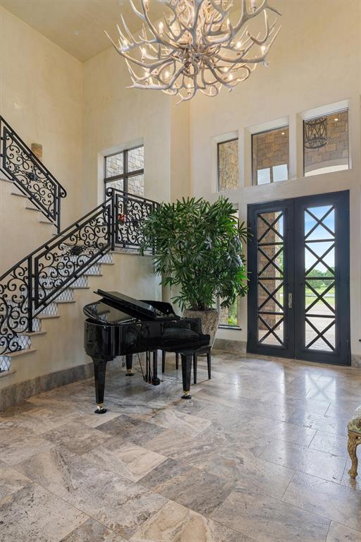 4400 NW 150th St, Oklahoma City, OK 73134 - foyer entrance with a chandelier, stone tile floors, a high ceiling, stairway, and french doors