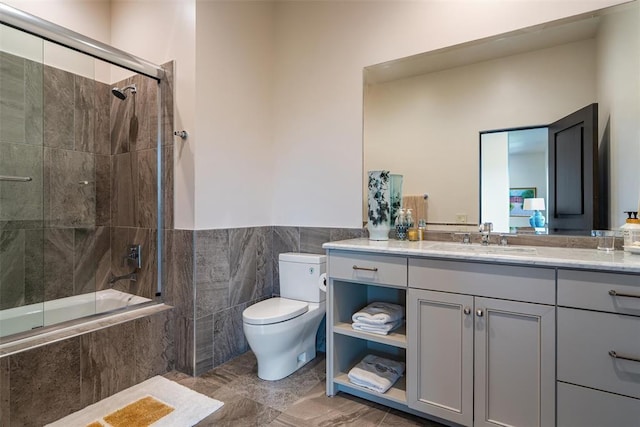 4400 NW 150th St, Oklahoma City, OK 73134 - full bath featuring tiled shower / bath combo, toilet, vanity, tile walls, and wainscoting