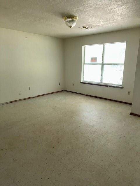 116 N Mahan St, El Reno, OK 73036 - unfurnished room featuring a textured ceiling and baseboards