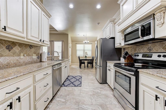 12360 Hidden Run Rd, Guthrie, OK 73044 - kitchen with stainless steel appliances, a sink, a chandelier, light stone counters, and recessed lighting