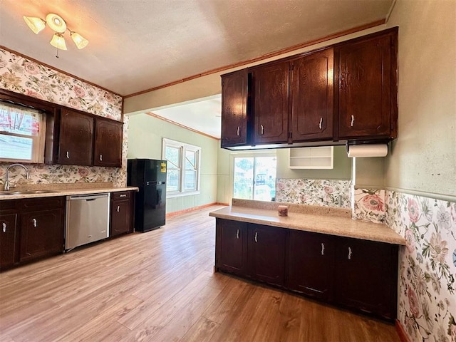 kitchen with dishwasher, freestanding refrigerator, a sink, light wood finished floors, and crown molding