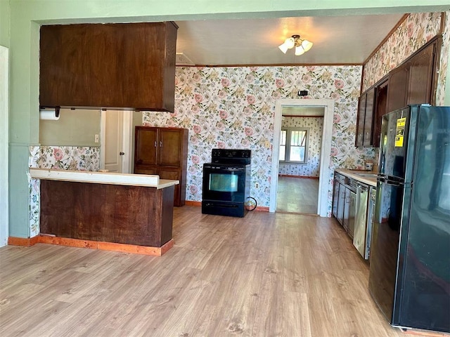 kitchen featuring black appliances, wallpapered walls, light wood-style floors, light countertops, and crown molding