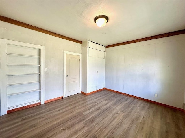 unfurnished bedroom with wood finished floors, a closet, and baseboards