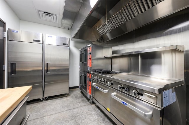 124 N Main St, Broken Bow, OK 74728 - kitchen with butcher block countertops, open shelves, premium range hood, stainless steel built in fridge, and concrete flooring