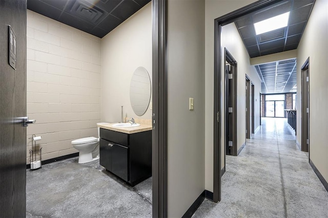 124 N Main St, Broken Bow, OK 74728 - bathroom with finished concrete flooring, baseboards, toilet, and vanity