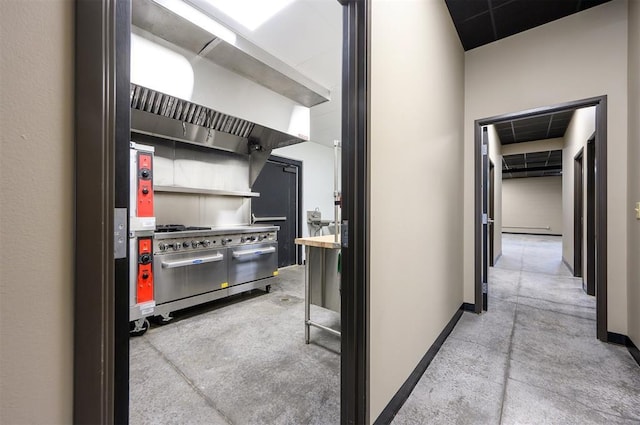 124 N Main St, Broken Bow, OK 74728 - kitchen with double oven range, baseboards, and wall chimney range hood