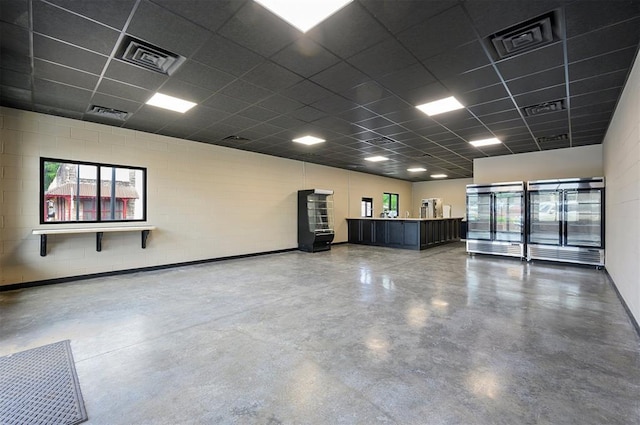 124 N Main St, Broken Bow, OK 74728 - spare room with finished concrete floors, a drop ceiling, and concrete block wall