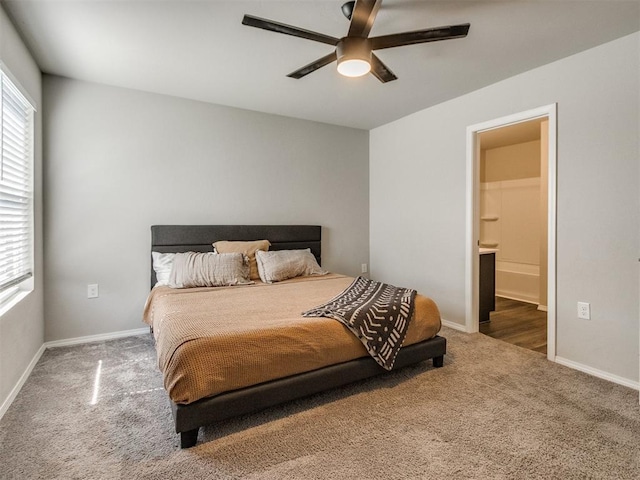 carpeted bedroom with baseboards, ensuite bathroom, and a ceiling fan