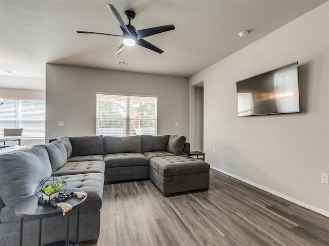 living area featuring ceiling fan, plenty of natural light, wood finished floors, and baseboards