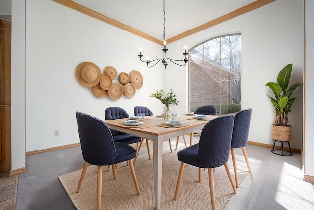 dining area with a chandelier, baseboards, carpet flooring, and crown molding