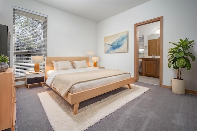 bedroom featuring a sink, light colored carpet, and ensuite bathroom