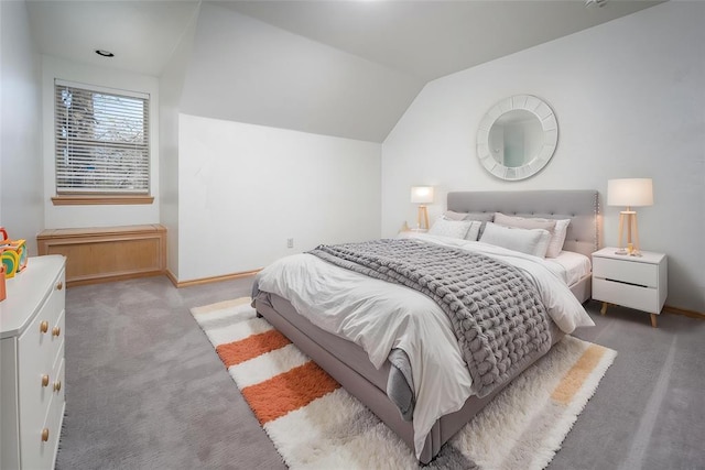 carpeted bedroom featuring vaulted ceiling and baseboards