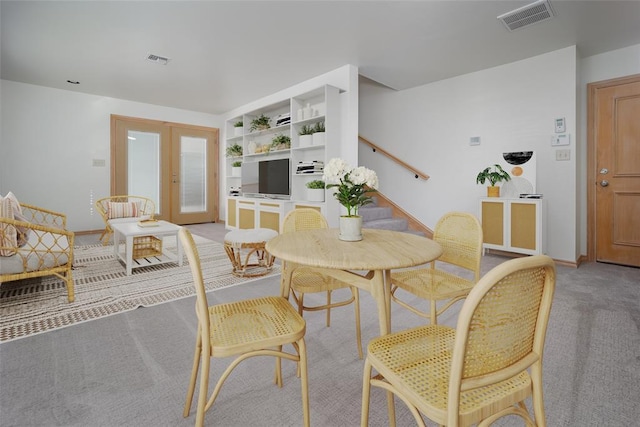 dining area with french doors, stairs, light carpet, and baseboards