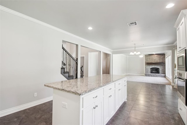 5625 Courtland Ln, Choctaw, OK 73020 - kitchen with a chandelier, a center island, open floor plan, crown molding, and appliances with stainless steel finishes