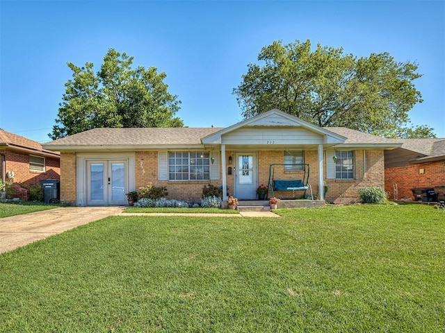 717 SW 4th Pl, Moore, OK 73160 - single story home with a front lawn, french doors, and brick siding