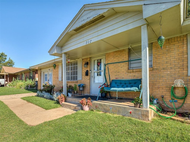 717 SW 4th Pl, Moore, OK 73160 - view of front facade featuring a porch, brick siding, and a front yard