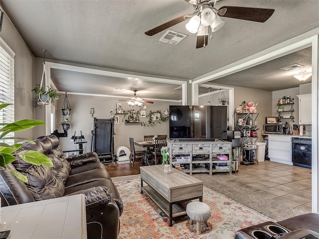 717 SW 4th Pl, Moore, OK 73160 - living room with ceiling fan, a textured ceiling, and light tile patterned floors