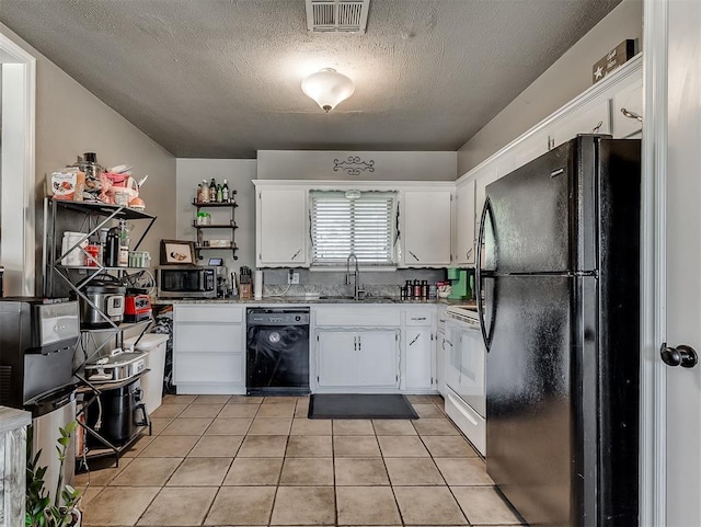 717 SW 4th Pl, Moore, OK 73160 - kitchen featuring black appliances, a textured ceiling, white cabinets, light tile patterned floors, and a sink