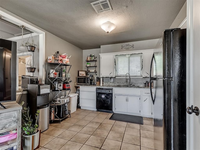 717 SW 4th Pl, Moore, OK 73160 - kitchen featuring black appliances, a sink, white cabinetry, light tile patterned floors, and a textured ceiling