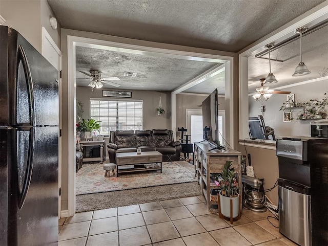 717 SW 4th Pl, Moore, OK 73160 - living room with a ceiling fan, a textured ceiling, and light tile patterned flooring