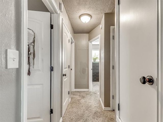 717 SW 4th Pl, Moore, OK 73160 - corridor featuring carpet flooring, a textured ceiling, and baseboards