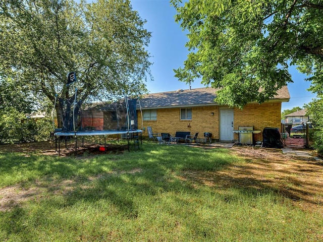 717 SW 4th Pl, Moore, OK 73160 - rear view of property featuring a trampoline and brick siding