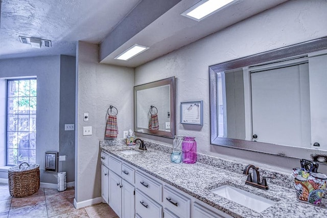 3517 Brookford Dr, Norman, OK 73072 - full bathroom featuring a textured wall, double vanity, tile patterned flooring, a textured ceiling, and baseboards