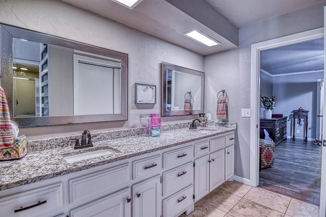 3517 Brookford Dr, Norman, OK 73072 - bathroom with double vanity, tile patterned floors, a textured wall, and baseboards