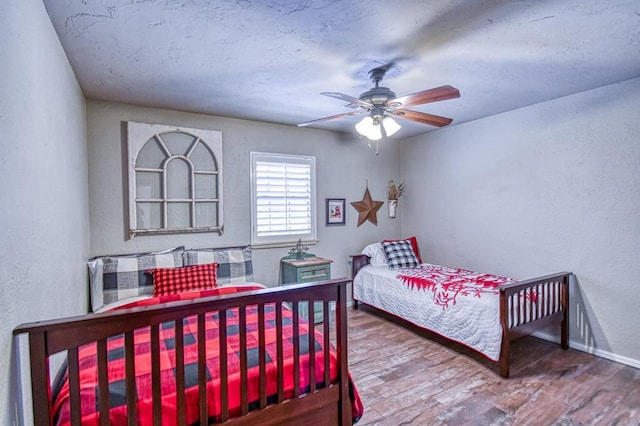 3517 Brookford Dr, Norman, OK 73072 - bedroom featuring a textured wall, wood finished floors, baseboards, and a ceiling fan