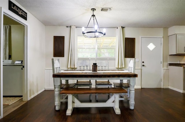 308 E Highland St, Hugo, OK 74743 - dining area with a chandelier, washer and clothes dryer, wood finished floors, a textured ceiling, and baseboards