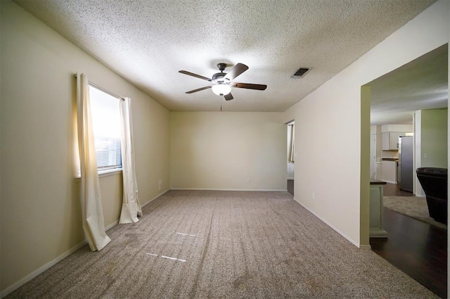 308 E Highland St, Hugo, OK 74743 - carpeted spare room featuring ceiling fan, a textured ceiling, and baseboards